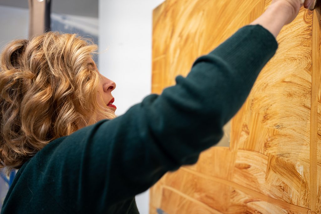 woman hanging painting